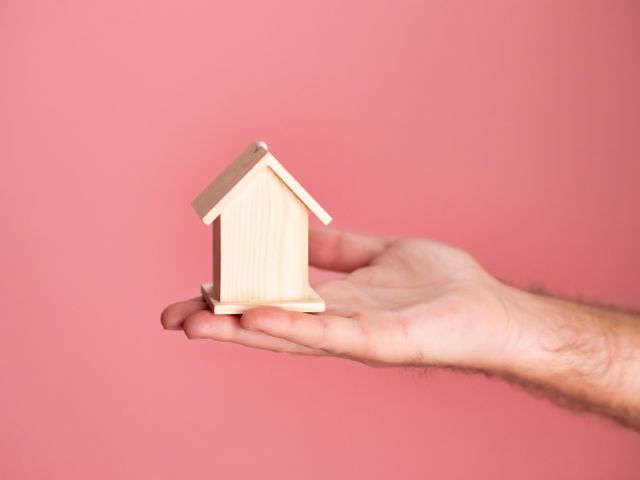 a%20hand%20holding%20a%20small,%20wooden%20house%20model a%20hand%20holding%20a%20small,%20wooden%20house%20model